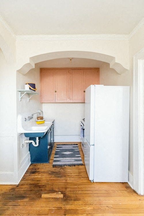 A kitchen with a sink and a refrigerator.