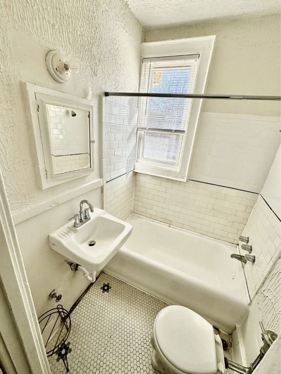 A white bathroom with a toilet, sink, and bathtub.