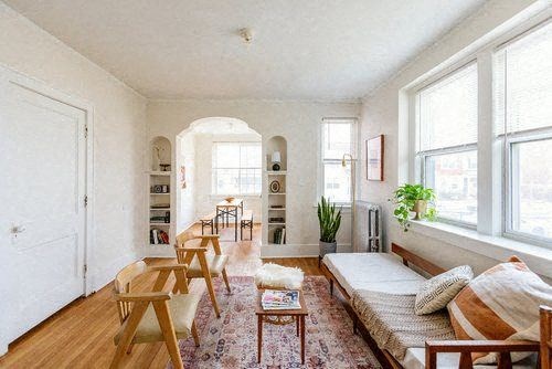 A living room with a sofa, chairs, and a rug.