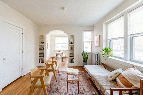 A living room with a sofa, chairs, and a rug.