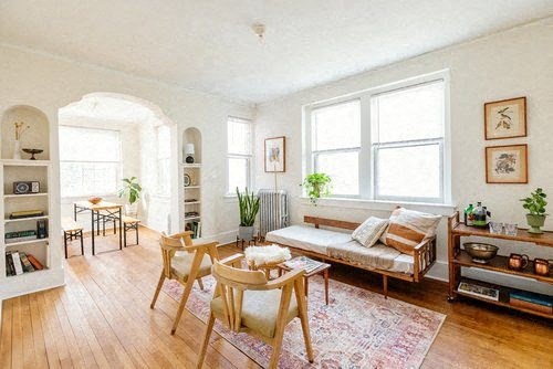 A living room with a sofa, a table, and a bookshelf.