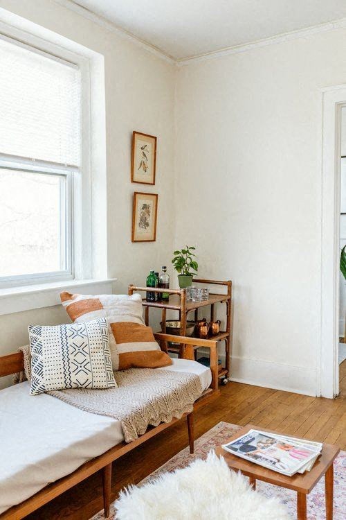 A bedroom with a bed, a table, and a window.