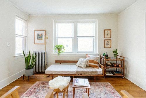 A cozy bedroom with a bed, a chair, and a table.
