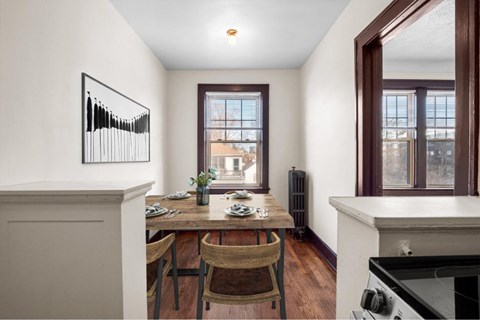 A dining room with a wooden table and chairs.