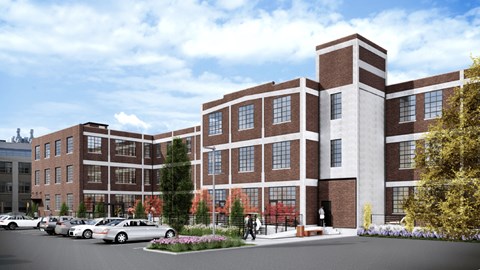 A large red brick building with a parking lot in front.