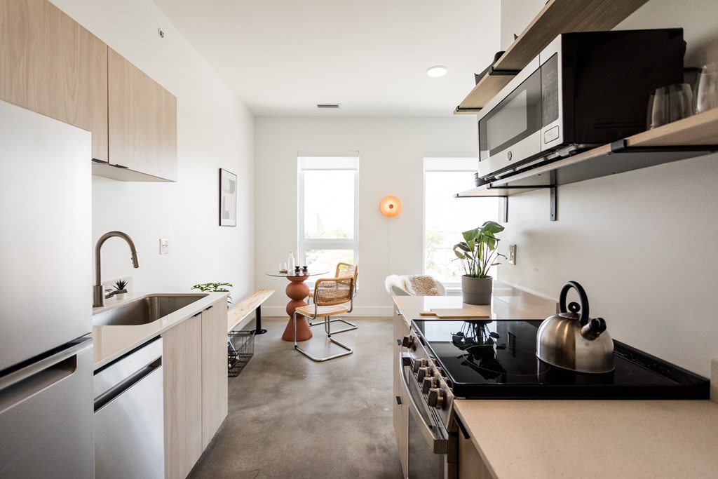 A modern kitchen with a black stove top and white appliances.