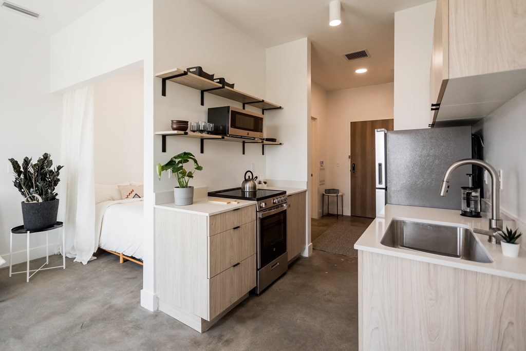 A modern kitchen with a sink, stove, and cabinets.