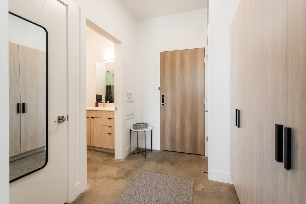 A hallway with a table and chairs in the middle.