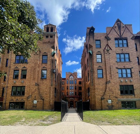 A large brick building with a black gate in front.