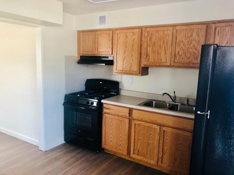 A kitchen with wooden cabinets and black appliances.