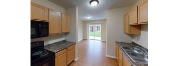 A kitchen with wooden cabinets and a black stove top oven.
