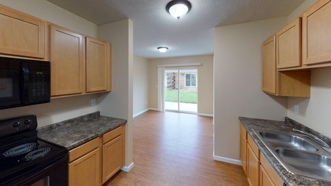 A kitchen with wooden cabinets and a black stove top oven.