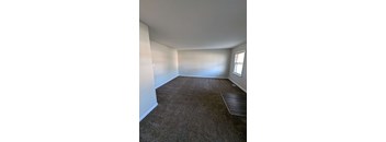 a empty room with a carpeted floor and a window