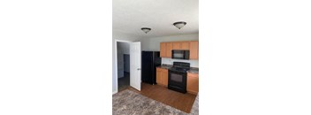 A kitchen with black appliances and wooden cabinets.