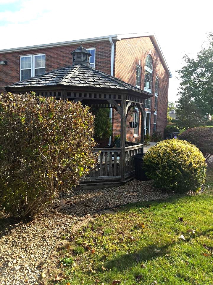 a gazebo in a yard in front of a house