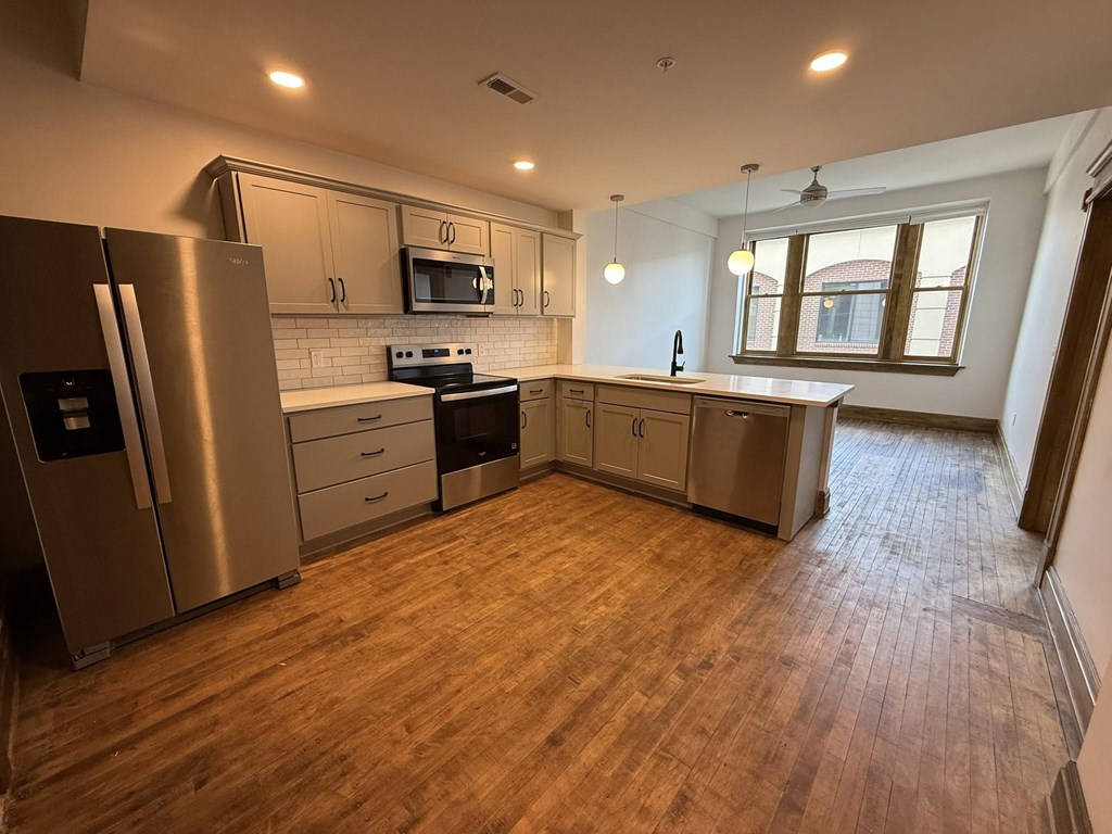 A kitchen with wooden floors and stainless steel appliances.