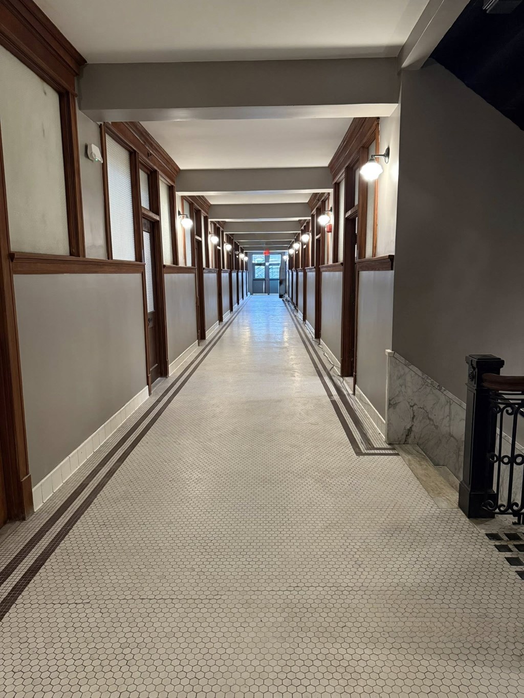 A long corridor with a tiled floor and walls.