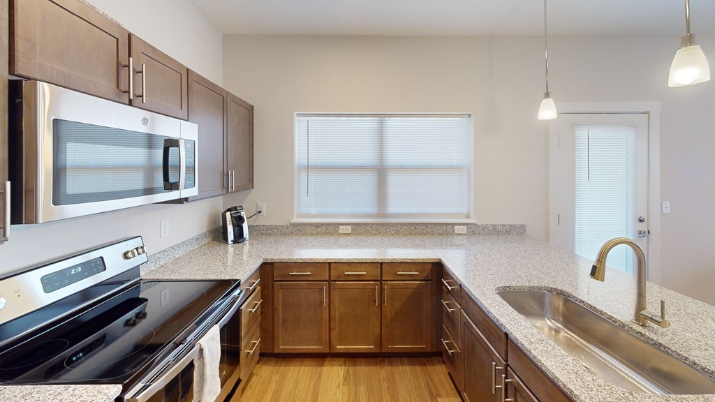 Kitchen with granite counter tops and wooden cabinets at The Landing Apartments, Indiana