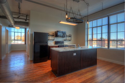 an empty kitchen with a large island and a large window