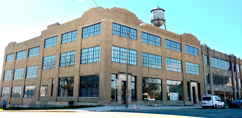 a large brick building with large windows and a water tower