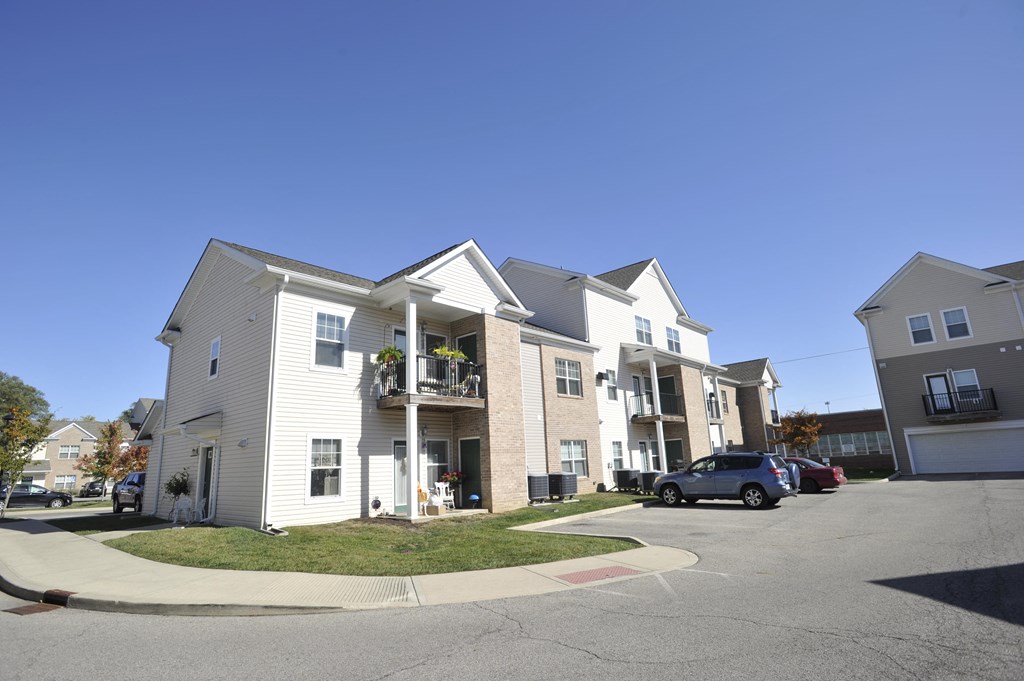 a row of houses with cars parked in front of them