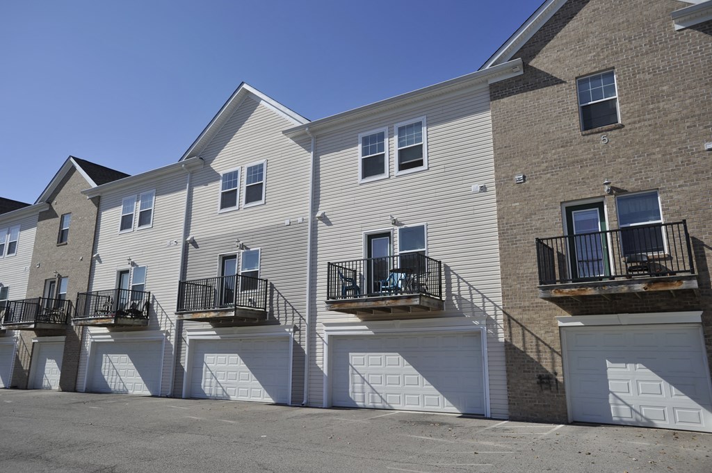 a row of town homes with white siding and white garages