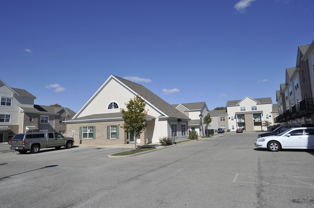 an empty parking lot in front of a row of houses