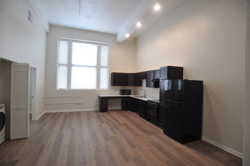 an empty apartment with a kitchen and a window