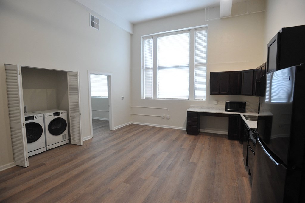 a kitchen and living room with a washer and dryer and a window