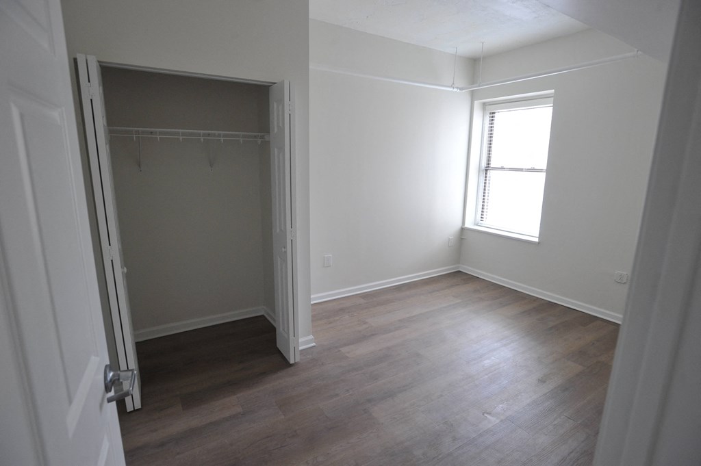 an empty room with a closet and a window