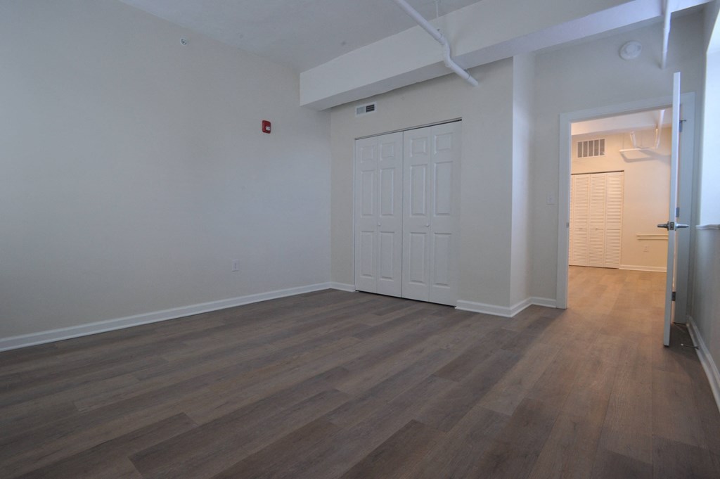an empty living room with wood flooring and a white door