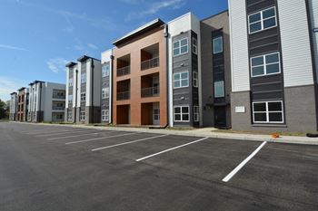 an empty parking lot in front of an apartment building
