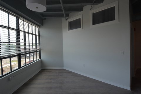 a living room with a large window and white walls