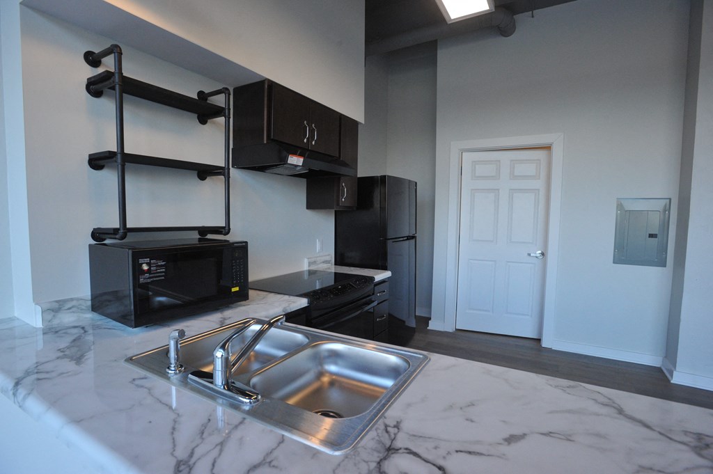 a kitchen with black cabinets and a sink and a black