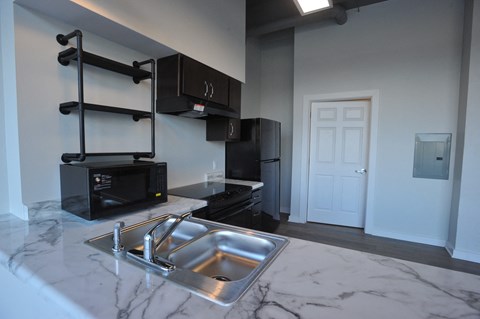 a kitchen with black cabinets and a sink and a black