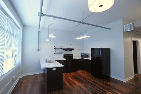 a kitchen and living room with wood flooring and a large window