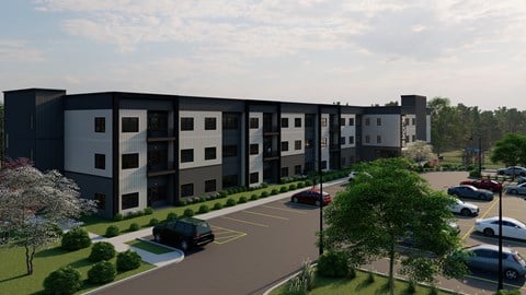 A modern apartment complex with a parking lot in front.