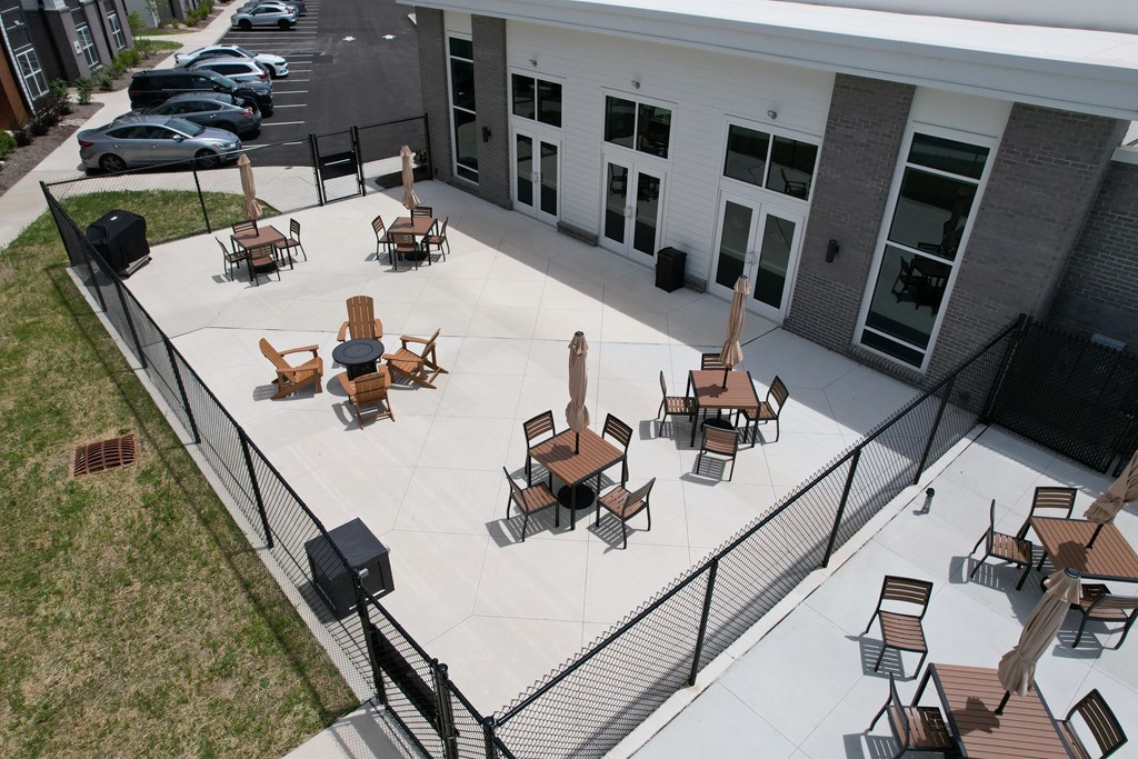 a patio with tables and chairs in front of a building