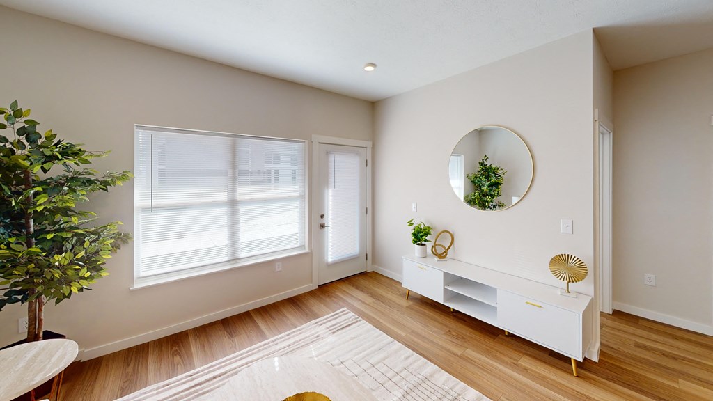 a living room with a large window and a door and a mirror  at The Landing Apartments, Indianapolis, IN, 46234