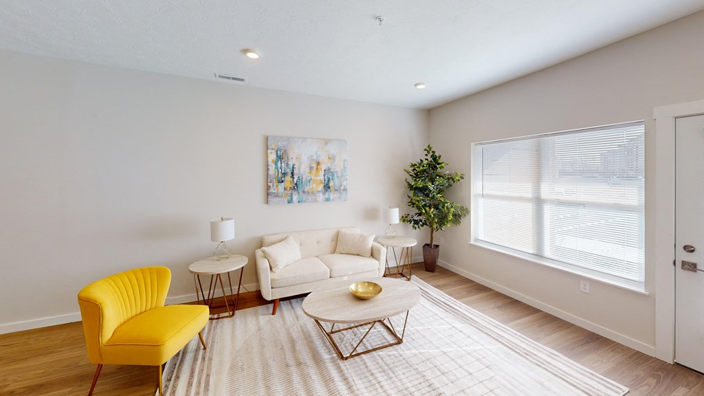 a living room with a white couch and yellow chairs  at The Landing Apartments, Indianapolis, Indiana