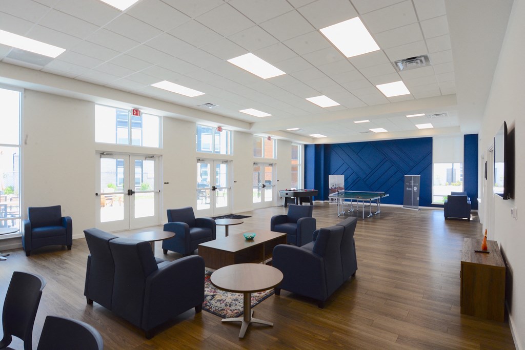 a large room with blue chairs and tables and windows