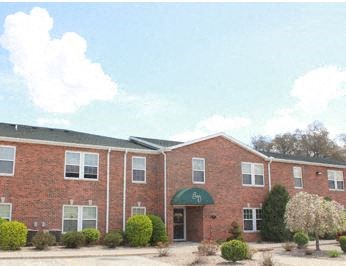the front of a brick building with a green awning