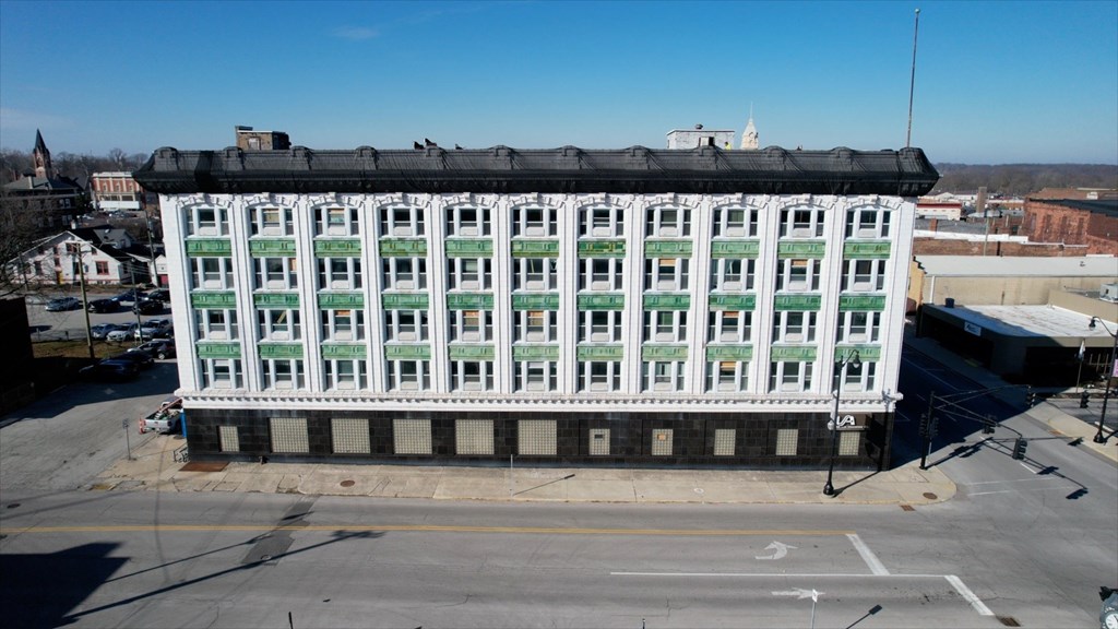 A large white building with green trim and a black roof.
