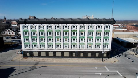 A large white building with green trim and a black roof.