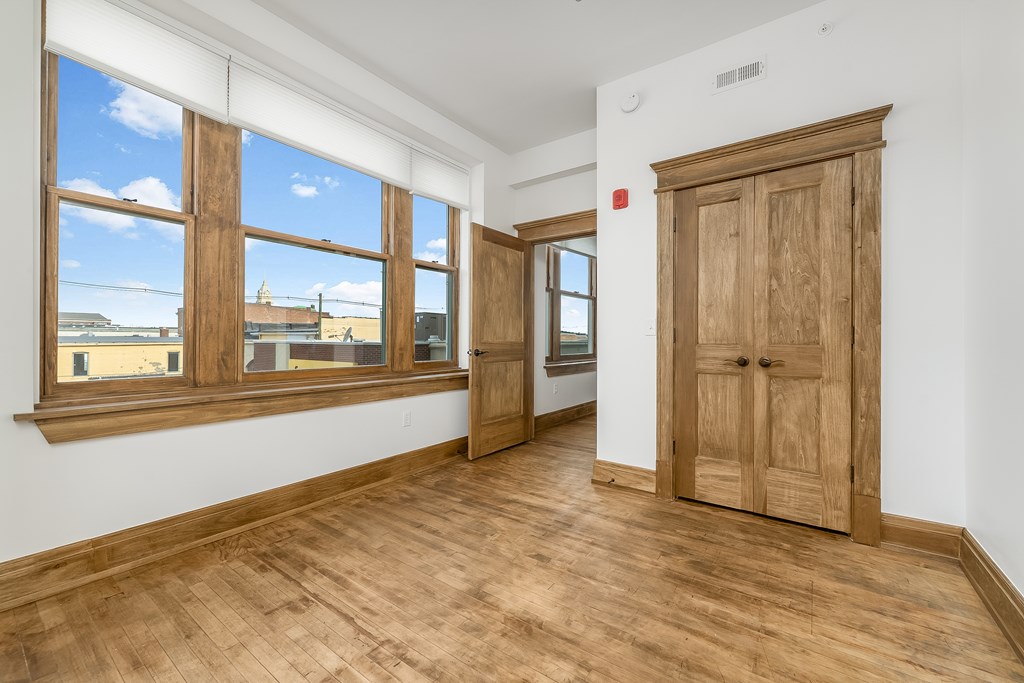 A room with wooden floors and a large window.