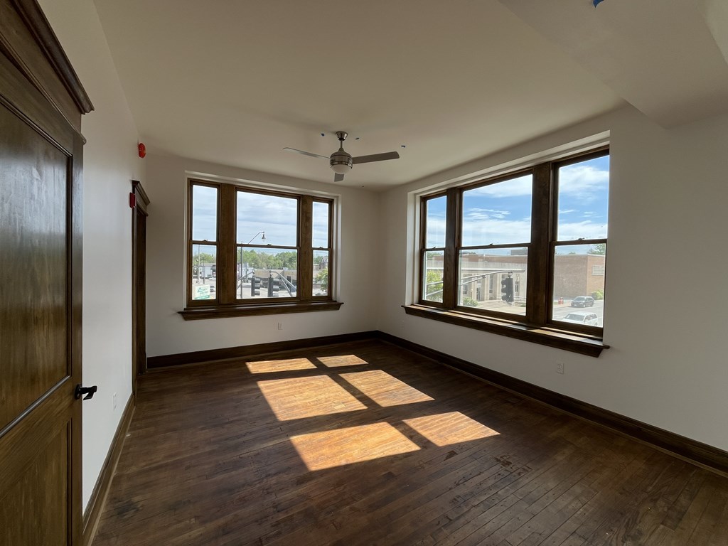 A room with wooden floors and a ceiling fan.
