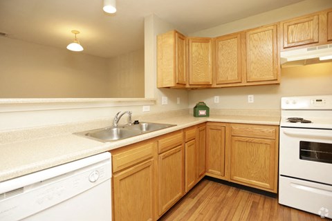 a kitchen with white appliances and wooden cabinets