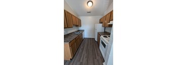 a kitchen with wood floors and white appliances