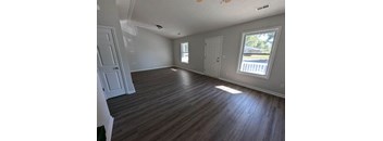 A room with wooden flooring and white walls.