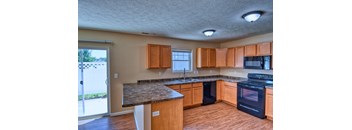 A kitchen with wooden cabinets and a granite countertop.